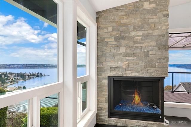 details featuring a stone fireplace and a water view