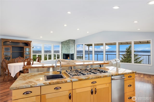 kitchen with stainless steel gas cooktop, plenty of natural light, a sink, vaulted ceiling, and open floor plan