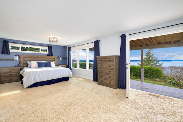 carpeted bedroom with access to exterior and baseboards