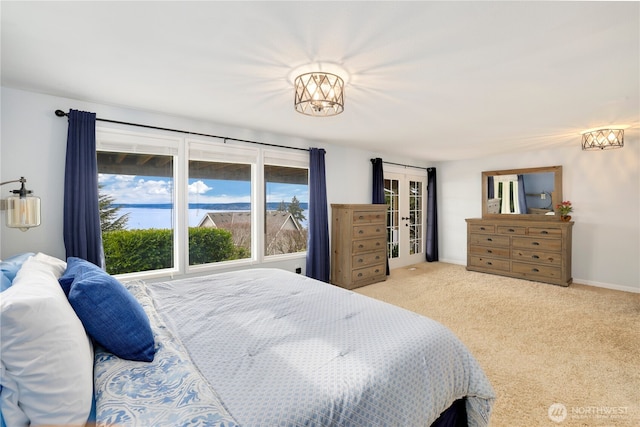 carpeted bedroom featuring french doors and baseboards