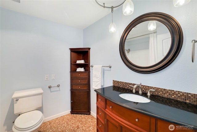 bathroom featuring decorative backsplash, toilet, vanity, and baseboards