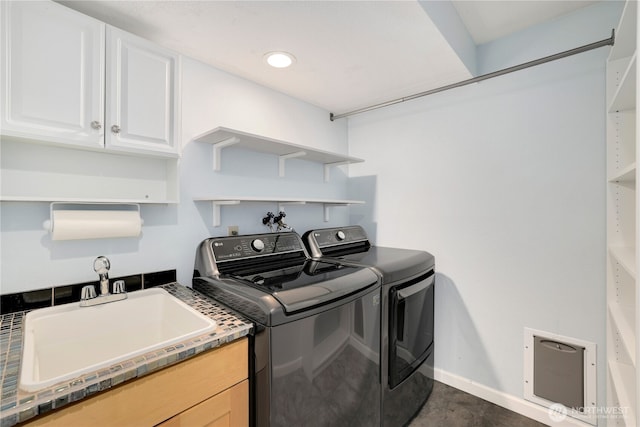 laundry room with baseboards, recessed lighting, cabinet space, a sink, and washer and clothes dryer