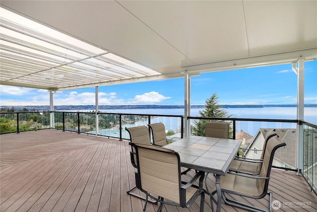 deck with a water view and outdoor dining space