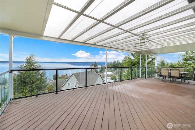 deck with outdoor dining area and a water view