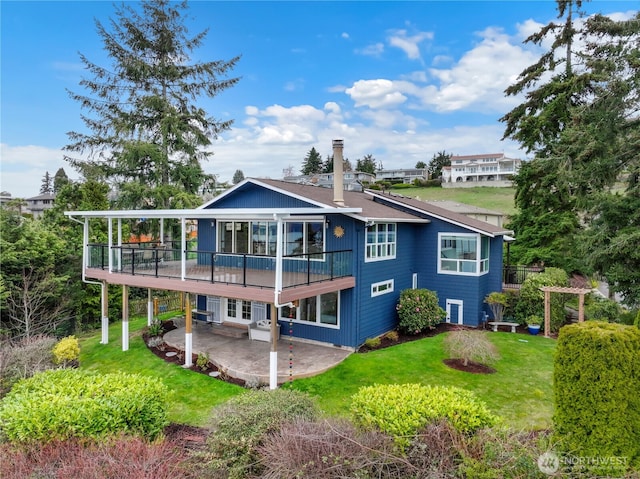 back of property with a patio area and a lawn