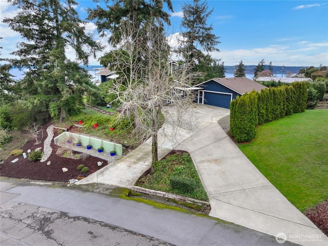 view of front facade featuring a front yard, an attached garage, and driveway