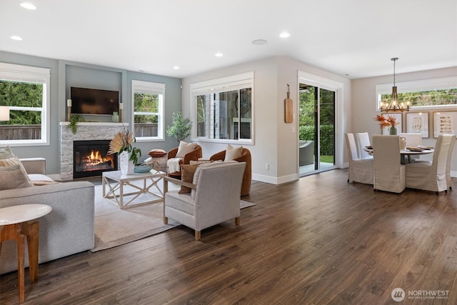 living area featuring baseboards, dark wood finished floors, an inviting chandelier, recessed lighting, and a fireplace