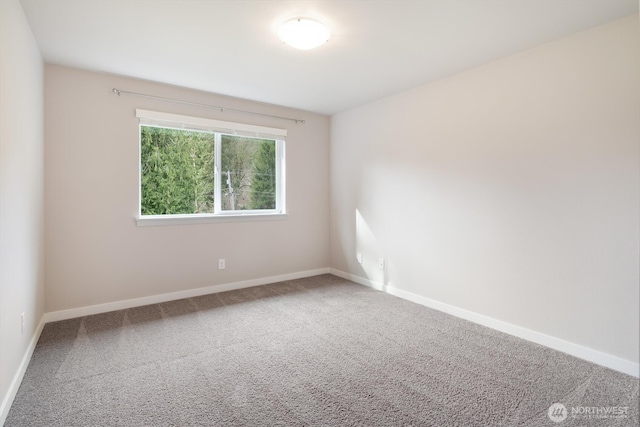 carpeted spare room featuring baseboards