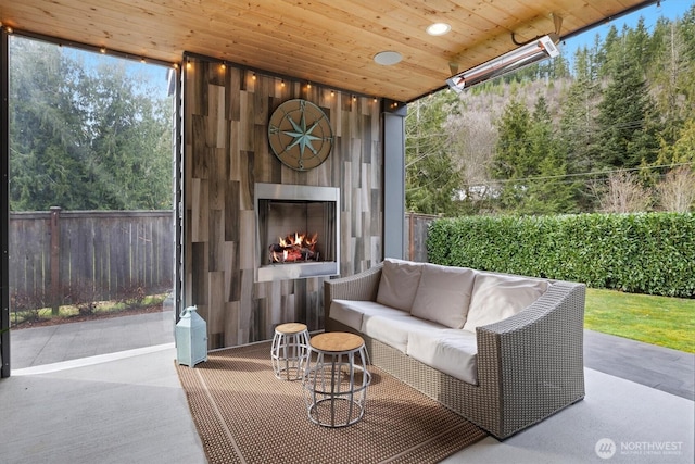 view of patio featuring an outdoor living space with a fireplace and fence