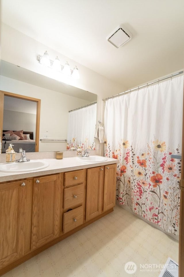 ensuite bathroom with tile patterned floors, ensuite bathroom, and a sink