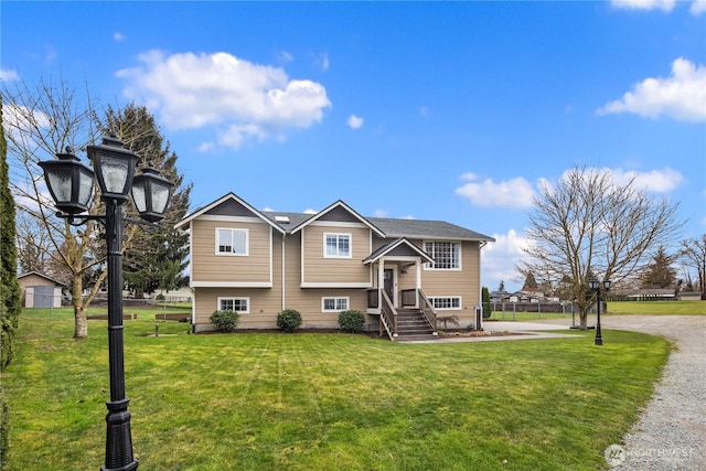 split foyer home with a front yard and fence