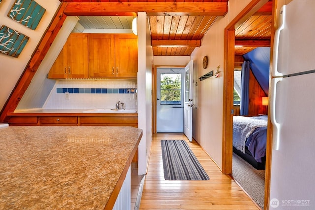 662 Mt Olympus Ave SE, Ocean Shores, WA 98569 - kitchen featuring freestanding refrigerator, a sink, wooden ceiling with exposed beams, light wood-type flooring, and decorative backsplash