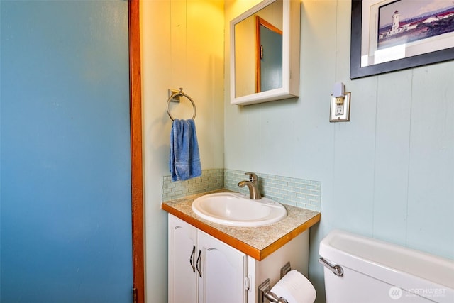662 Mt Olympus Ave SE, Ocean Shores, WA 98569 - bathroom with toilet, vanity, and decorative backsplash