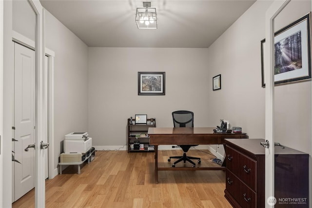 office area with light wood-type flooring and baseboards