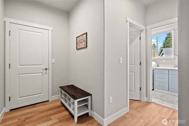 hallway featuring baseboards and light wood-style floors