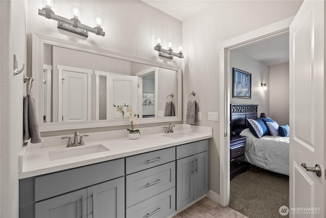 ensuite bathroom featuring double vanity, baseboards, ensuite bathroom, and a sink