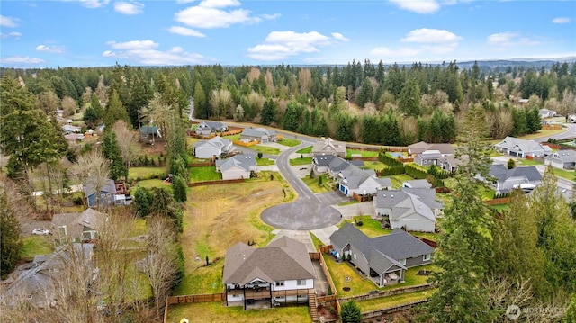 drone / aerial view with a residential view and a wooded view