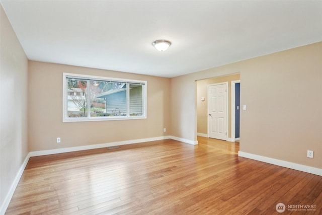 spare room with light wood finished floors and baseboards