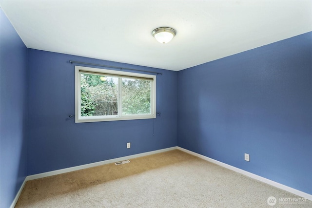 empty room featuring baseboards, visible vents, and carpet floors