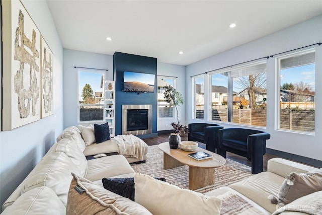 living room with recessed lighting, wood finished floors, baseboards, and a large fireplace