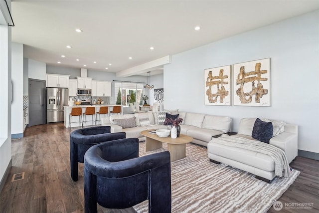 living area with recessed lighting, visible vents, baseboards, and dark wood finished floors