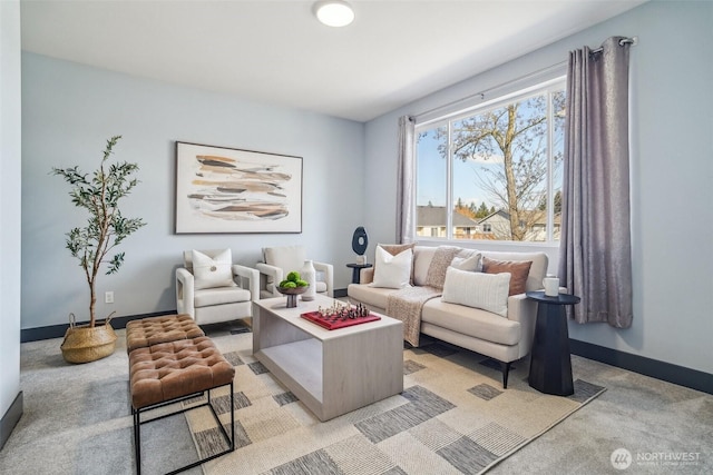 living area featuring baseboards and light carpet