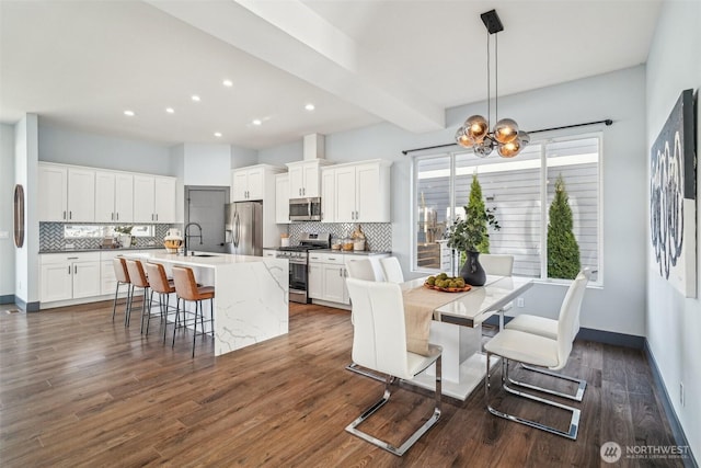 kitchen with dark wood finished floors, white cabinetry, appliances with stainless steel finishes, and a sink