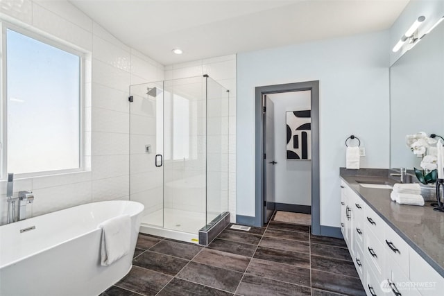 bathroom featuring a freestanding tub, recessed lighting, a shower stall, baseboards, and vanity