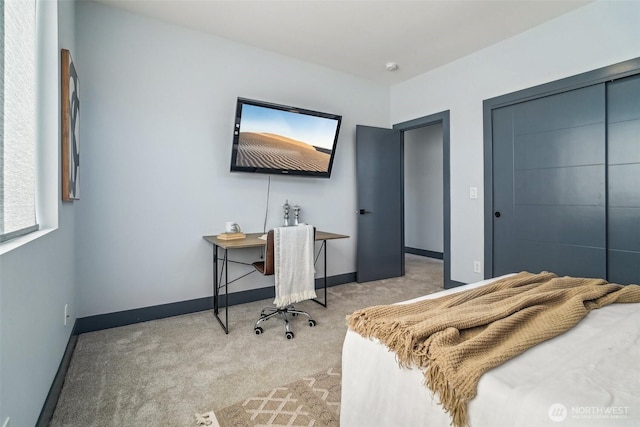 bedroom with light carpet, a closet, and baseboards