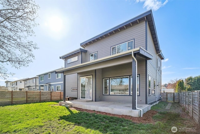 rear view of property with a yard, a fenced backyard, and a patio area