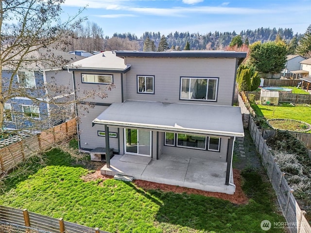 back of property with a patio, a yard, and a fenced backyard