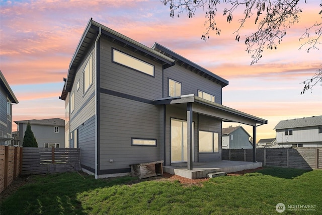 back of property featuring a patio area, a yard, and a fenced backyard