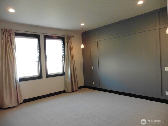 unfurnished room with light carpet, recessed lighting, and baseboards