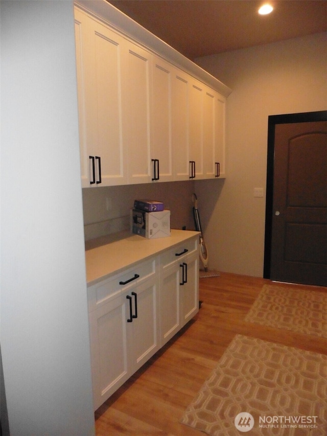 kitchen featuring light wood finished floors, recessed lighting, white cabinetry, and light countertops