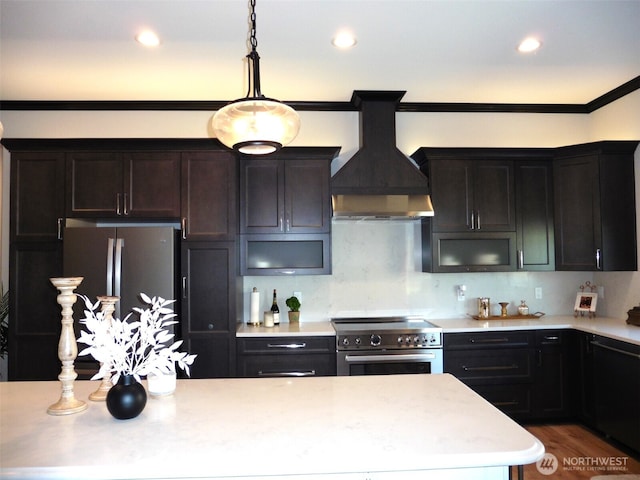 kitchen with premium range hood, light countertops, appliances with stainless steel finishes, crown molding, and decorative light fixtures