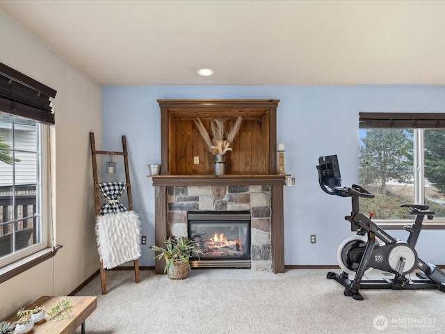 exercise area with baseboards, carpet, and a fireplace