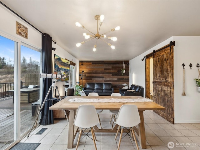 dining area with a notable chandelier, wooden walls, a barn door, and light tile patterned floors