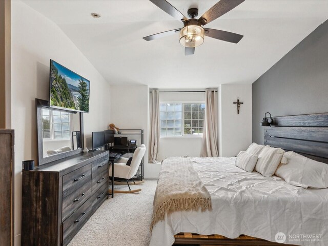 bedroom with ceiling fan, vaulted ceiling, and light carpet