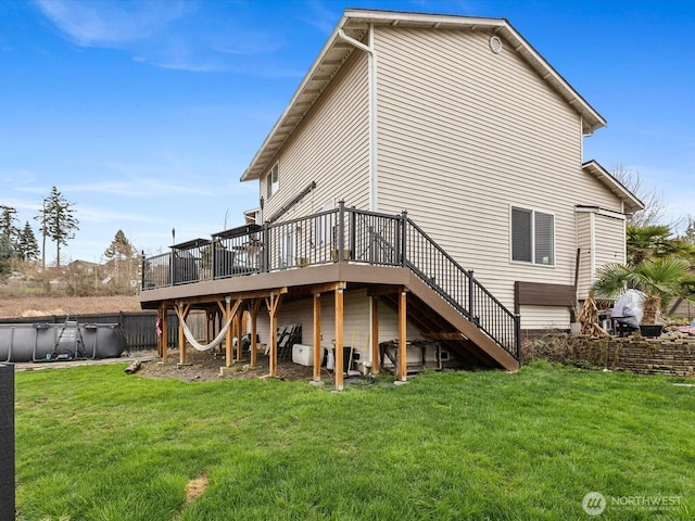 rear view of property with a lawn, a deck, stairs, and fence