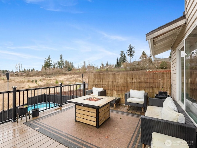 deck with a fenced in pool and an outdoor fire pit