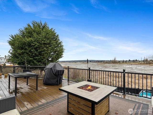 wooden deck featuring a fire pit and area for grilling