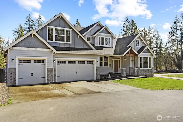 craftsman-style house featuring board and batten siding, a front lawn, roof with shingles, driveway, and an attached garage