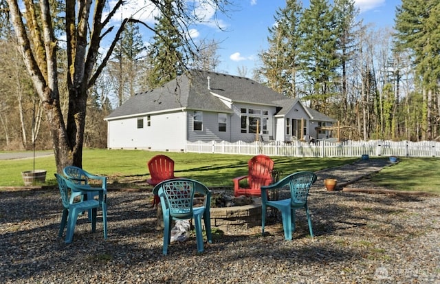 rear view of house with a lawn and fence