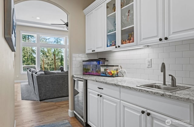 kitchen with white cabinets, beverage cooler, and a sink