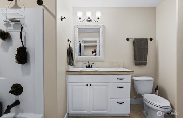 bathroom with toilet, vanity, and baseboards