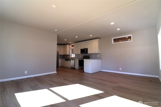 kitchen featuring white cabinets, recessed lighting, baseboards, and appliances with stainless steel finishes