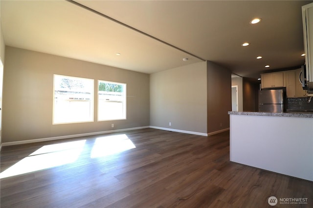 unfurnished living room featuring recessed lighting, dark wood-style floors, and baseboards