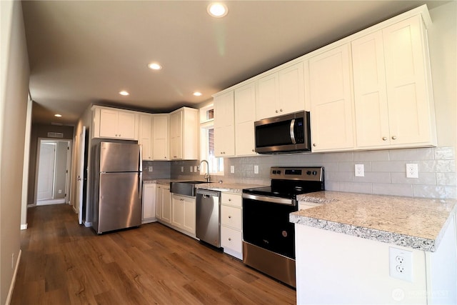 kitchen featuring tasteful backsplash, dark wood-type flooring, light countertops, recessed lighting, and stainless steel appliances