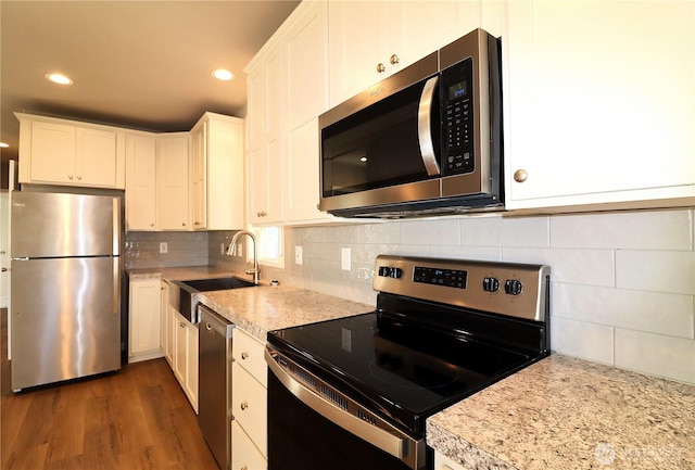 kitchen featuring white cabinetry, decorative backsplash, dark wood-style flooring, and stainless steel appliances