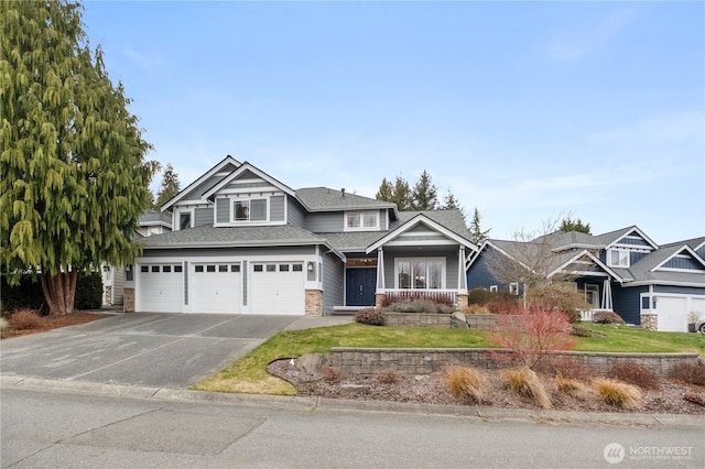 view of front facade featuring aphalt driveway, an attached garage, and a shingled roof